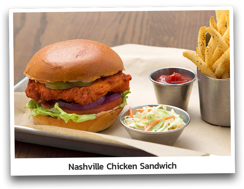 Picture if the Nashville Chicken Sandwich that consist of Crispy chicken breast tossed in Nashville hot sauce and topped with lettuce, tomato, red onion, and pickles placed between a hamburger bun. Served with a side of
