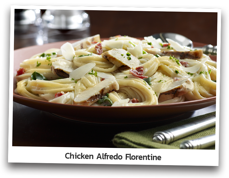 Chicken Alfredo Florentine dish presented on a round plate and made with roasted chicken breast, roasted tomatoes, fresh baby spinach and linguine tossed in Alfredo sauce and garnished with asiago cheese shavings.
