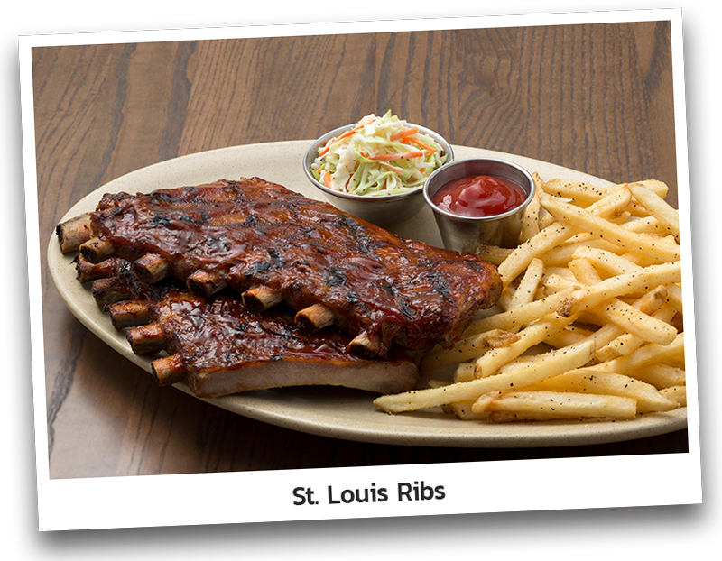 Full rack of St. Louis Ribs, meaty and tender pork ribs grilled with Original BBQ Sauce. Served with coleslaw, fries and ketchup on an oval plate.